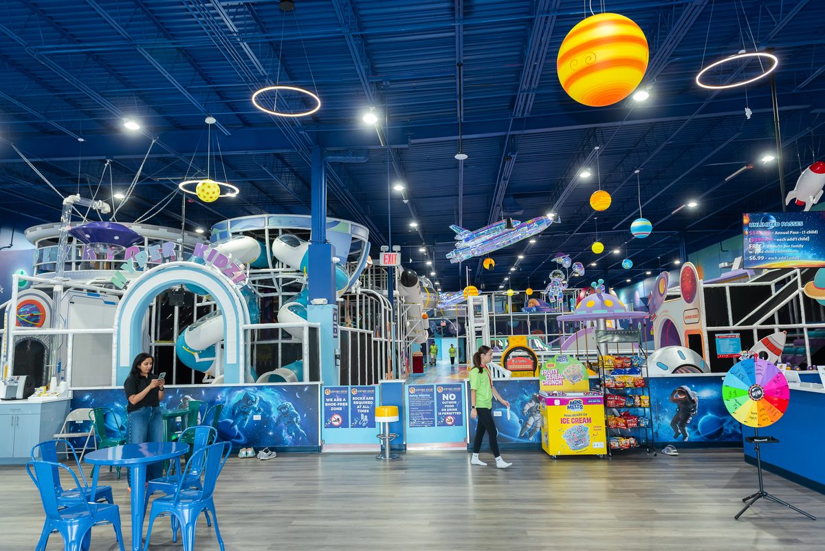 Wide view of the space-themed Hyper Kidz indoor playground with multi-level play structures